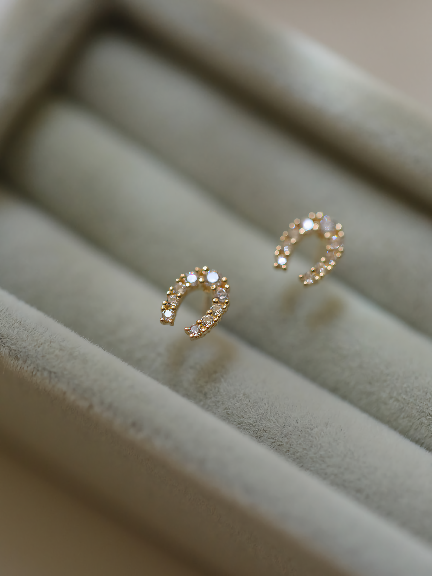 Close-up view of the 9ct solid gold horseshoe studs, reflecting the light to emphasize their lucky charm and elegance.