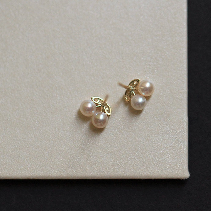 Image of 9ct solid gold studs designed as cherries, with pearls for fruit, reflecting the playful yet refined design of the earrings.