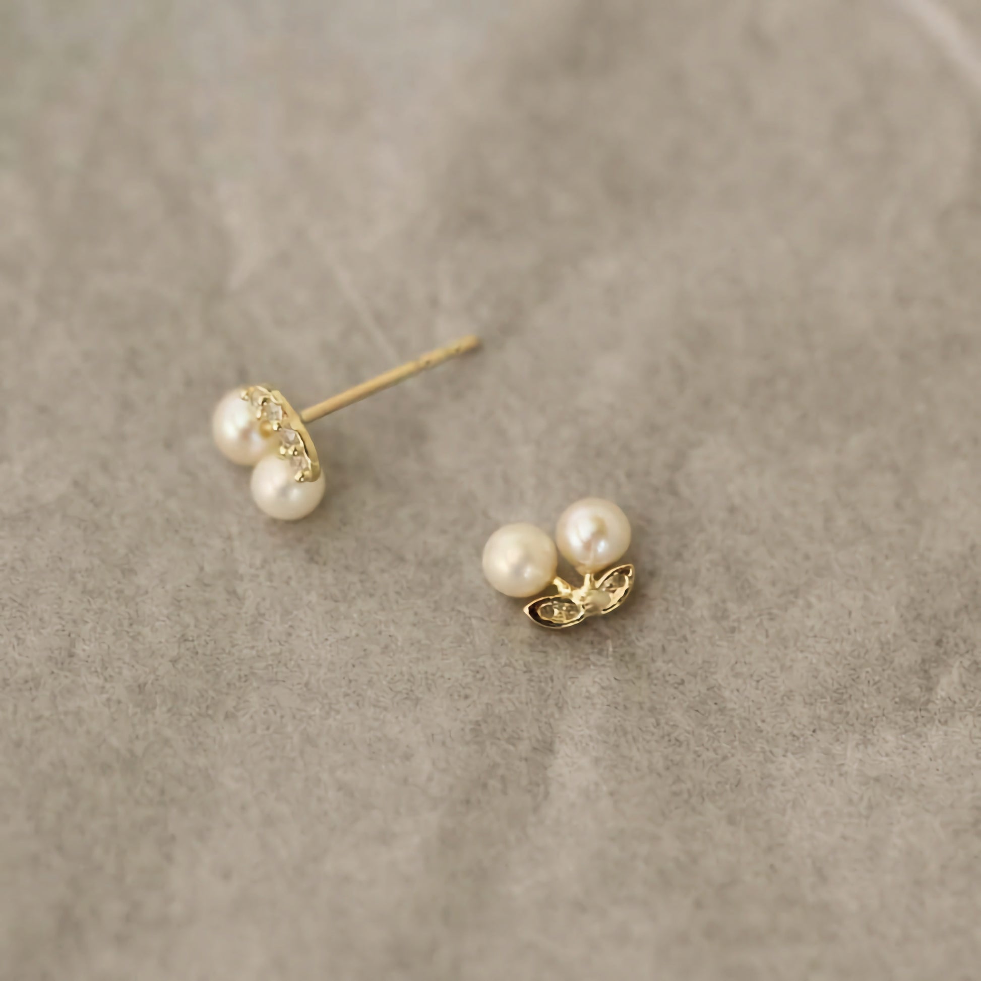 Close-up view of 9ct solid gold cherry-shaped earrings, featuring glossy pearls as the fruit.