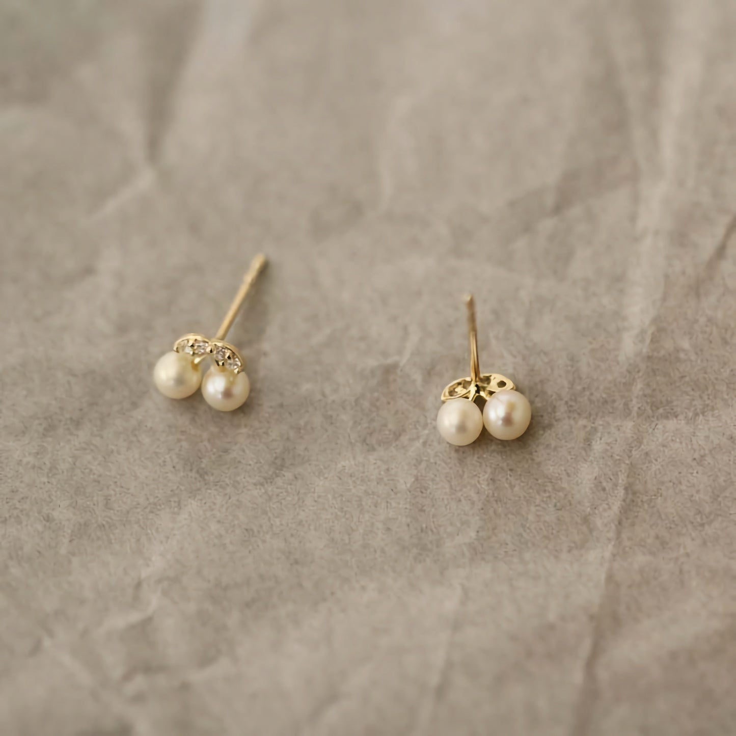 9ct solid gold earrings in the shape of cherries, where pearls serve as the fruit, emphasizing their charm and unique design.
